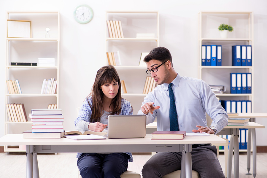 Tutor woman with a boy student studying